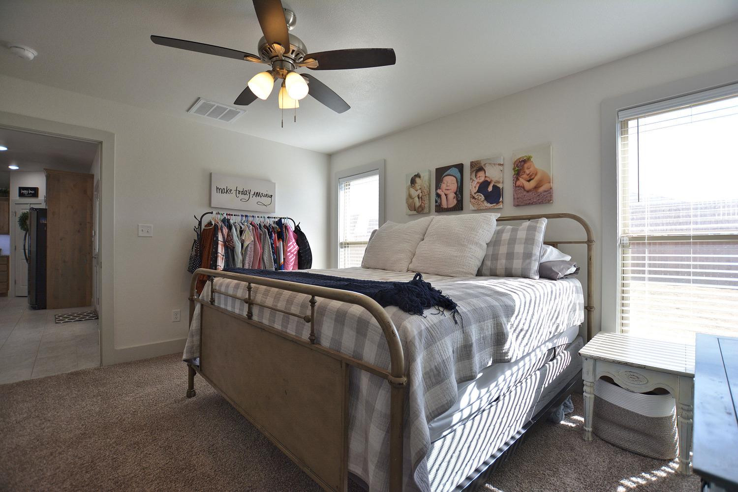 8901 Winfield Avenue Lubbock, TX 79424 - Photo 15 of 22 a bedroom with a bed and a chandelier