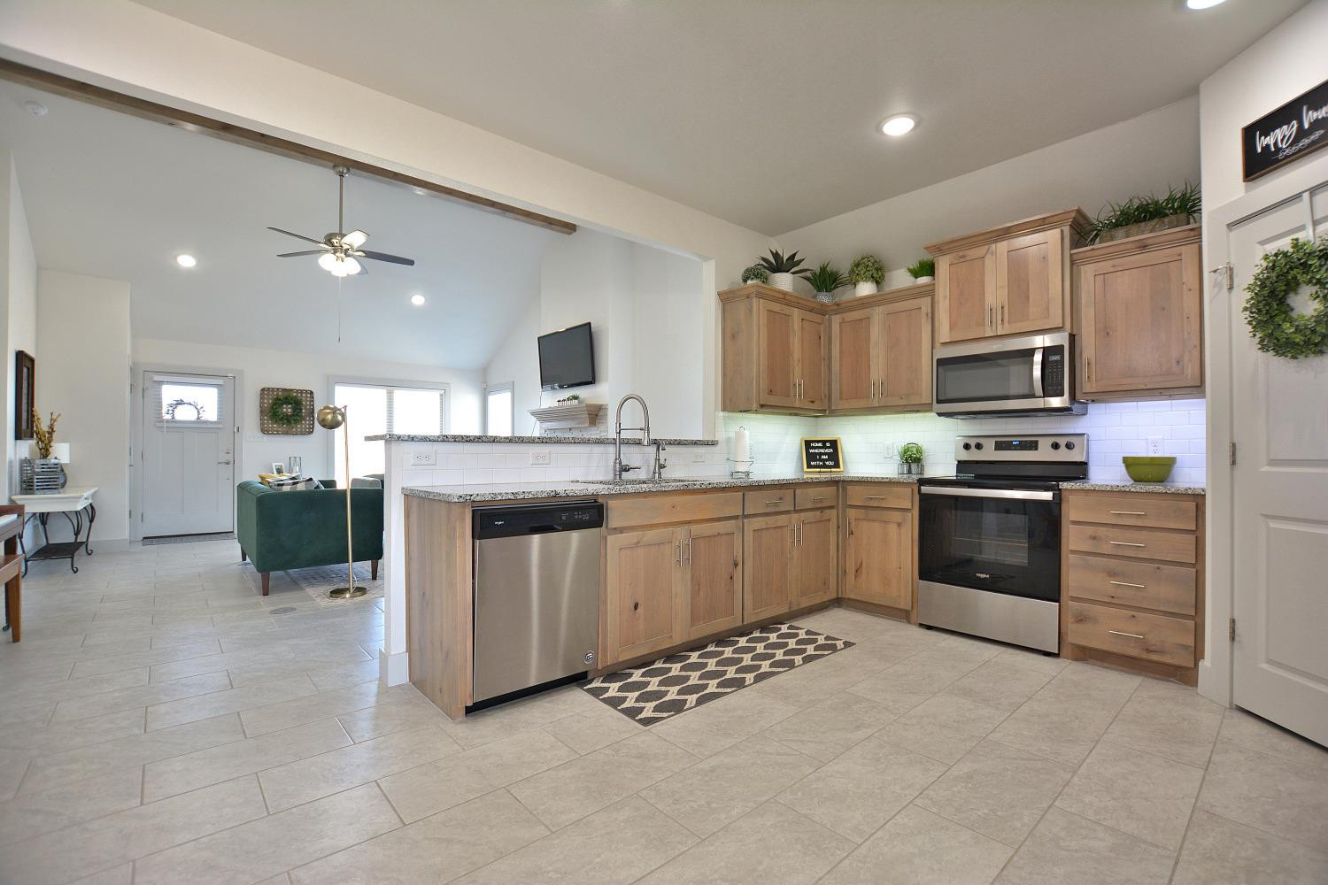8901 Winfield Avenue Lubbock, TX 79424 - Photo 9 of 22 a kitchen with stainless steel appliances a stove sink microwave and cabinets