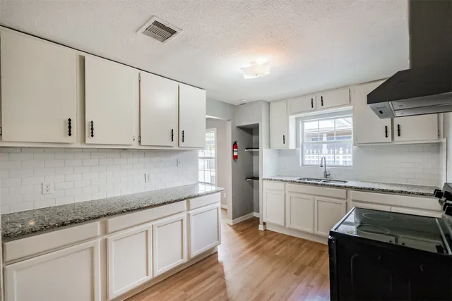 a kitchen with granite countertop white cabinets and white appliances