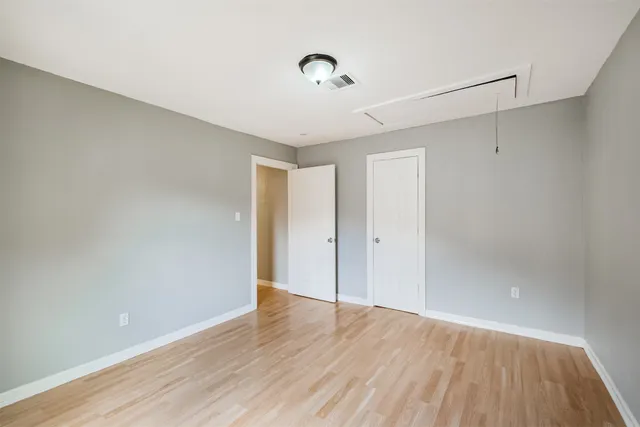 a view of an empty room with wooden floor