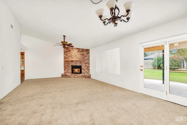 a living room with furniture ceiling fan and a large window