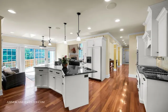a kitchen with granite countertop a stove a sink dishwasher and white cabinets with wooden floor