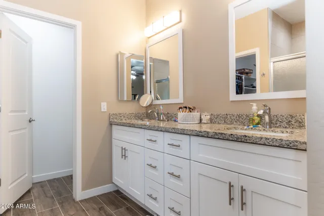 a bathroom with a granite countertop sink and a mirror