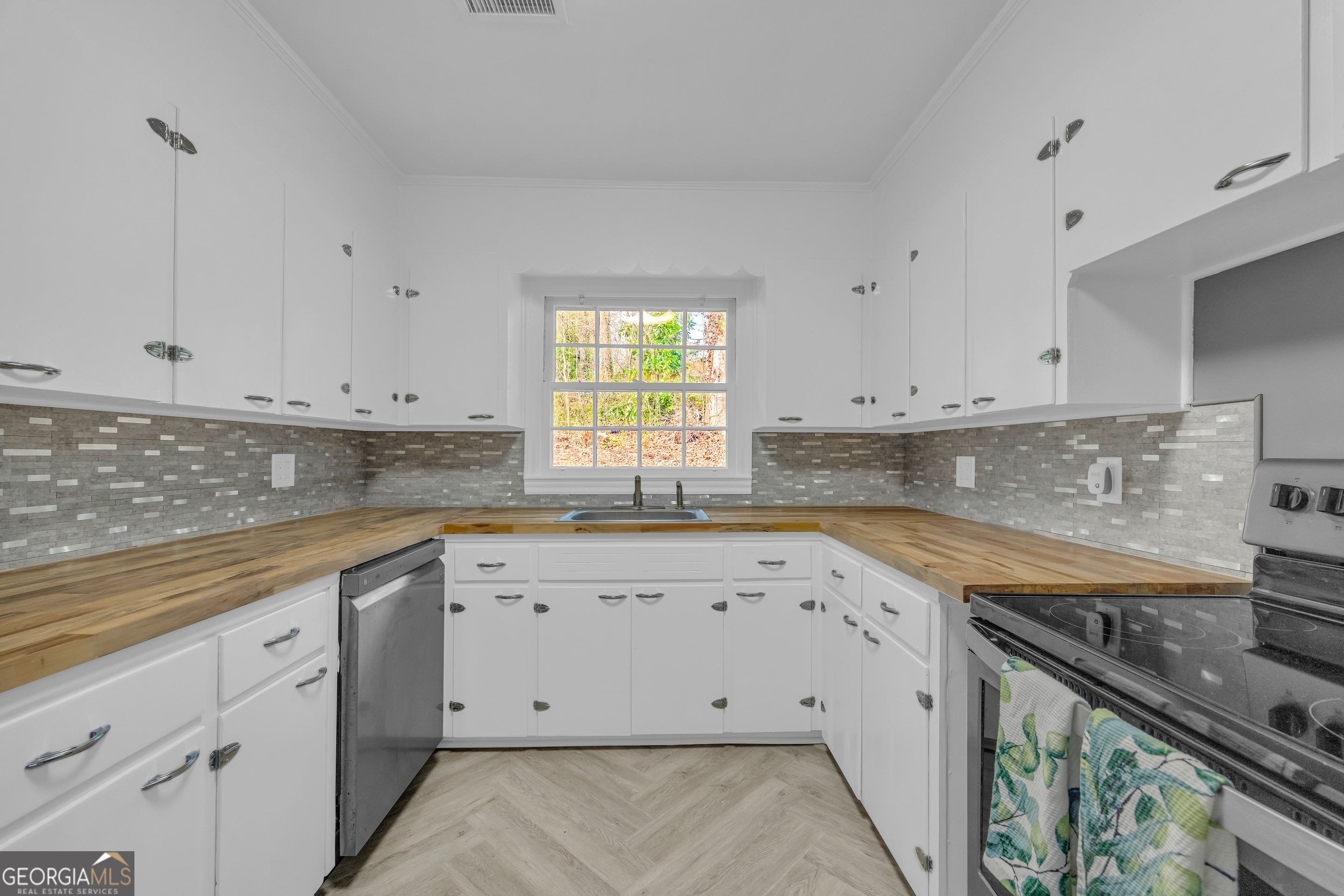 998 Rosedale Street Toccoa, GA 30577 - Photo 38 of 43 a kitchen with granite countertop white cabinets white appliances a sink and a stove