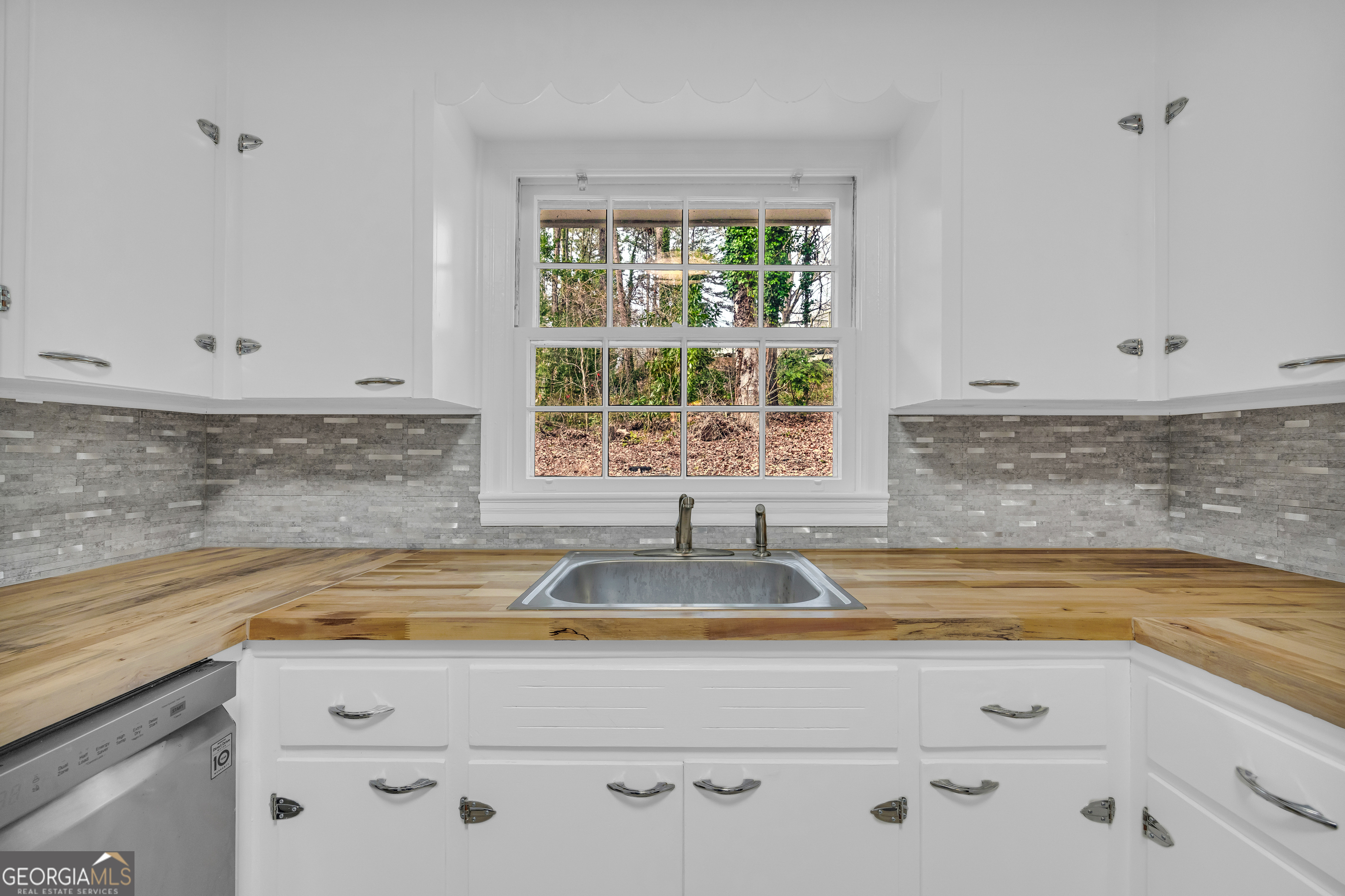 998 Rosedale Street Toccoa, GA 30577 - Photo 40 of 43 a view of a kitchen stove a sink and dishwasher with white cabinets