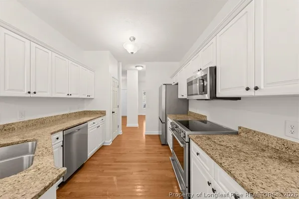 a kitchen with stainless steel appliances granite countertop a sink stove and cabinets