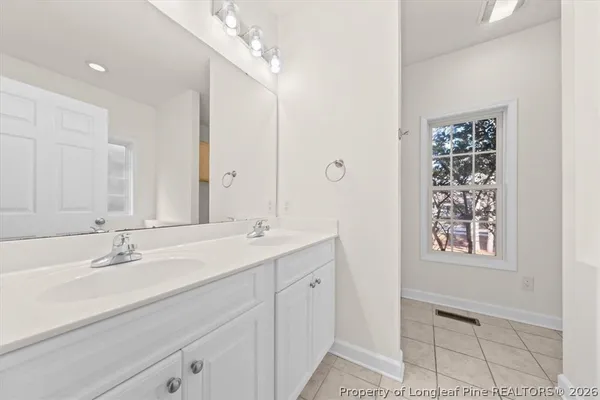 a bathroom with a double vanity sink and a mirror