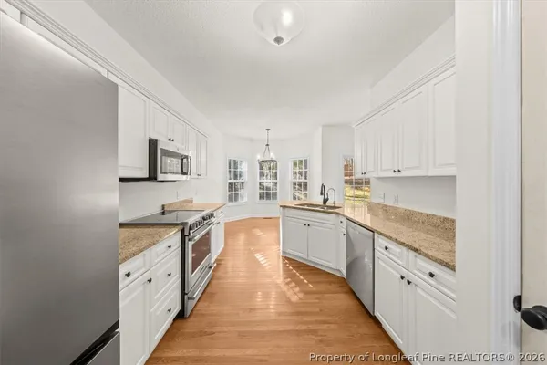 a large kitchen with cabinets stove top oven and sink