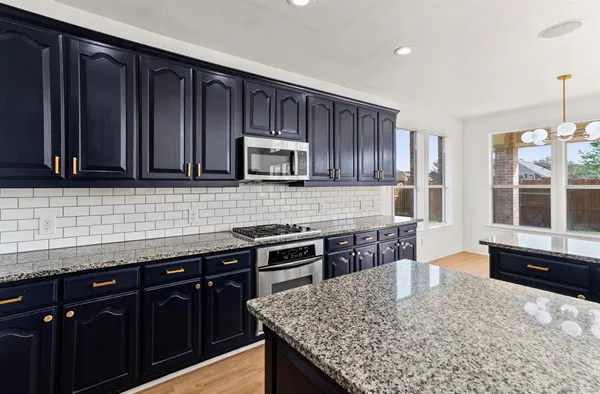 a kitchen with granite countertop wooden cabinets and a granite counter tops