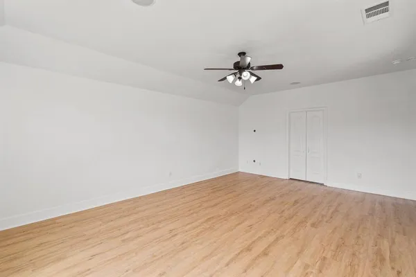 a view of a room with a wooden floor and a ceiling fan