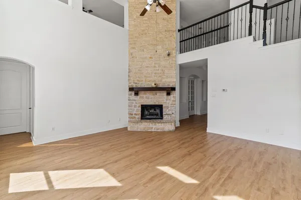 a view of empty room with wooden floor and fireplace