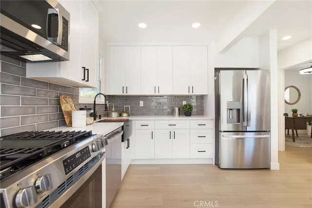 a kitchen with stainless steel appliances granite countertop a refrigerator stove microwave and cabinets