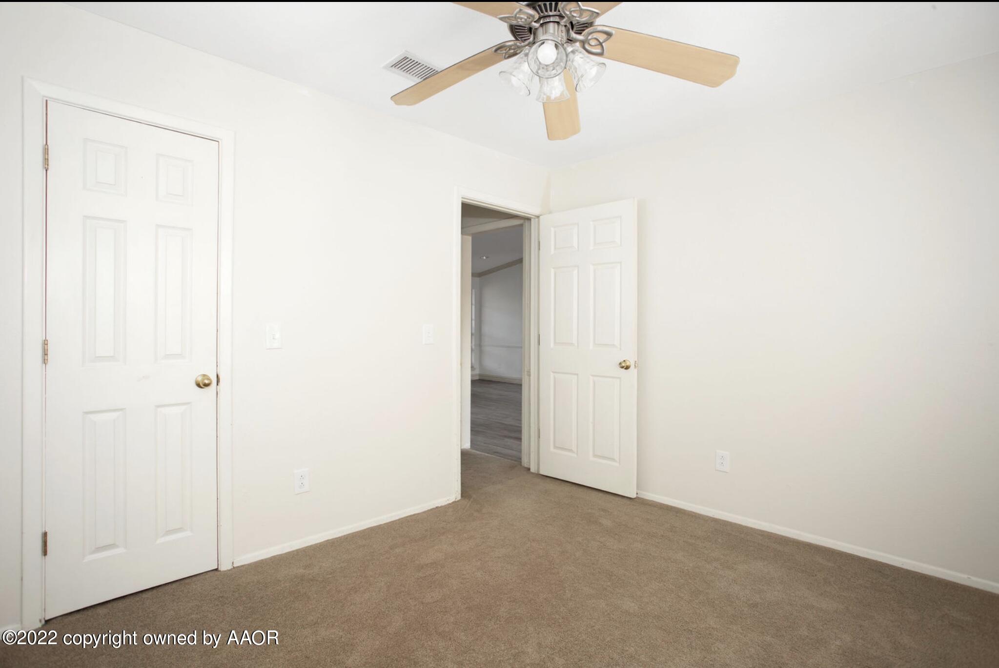 6700 Foothill Drive Amarillo, TX 79124 - Photo 3 of 17 an empty room with a chandelier fan and a bathroom