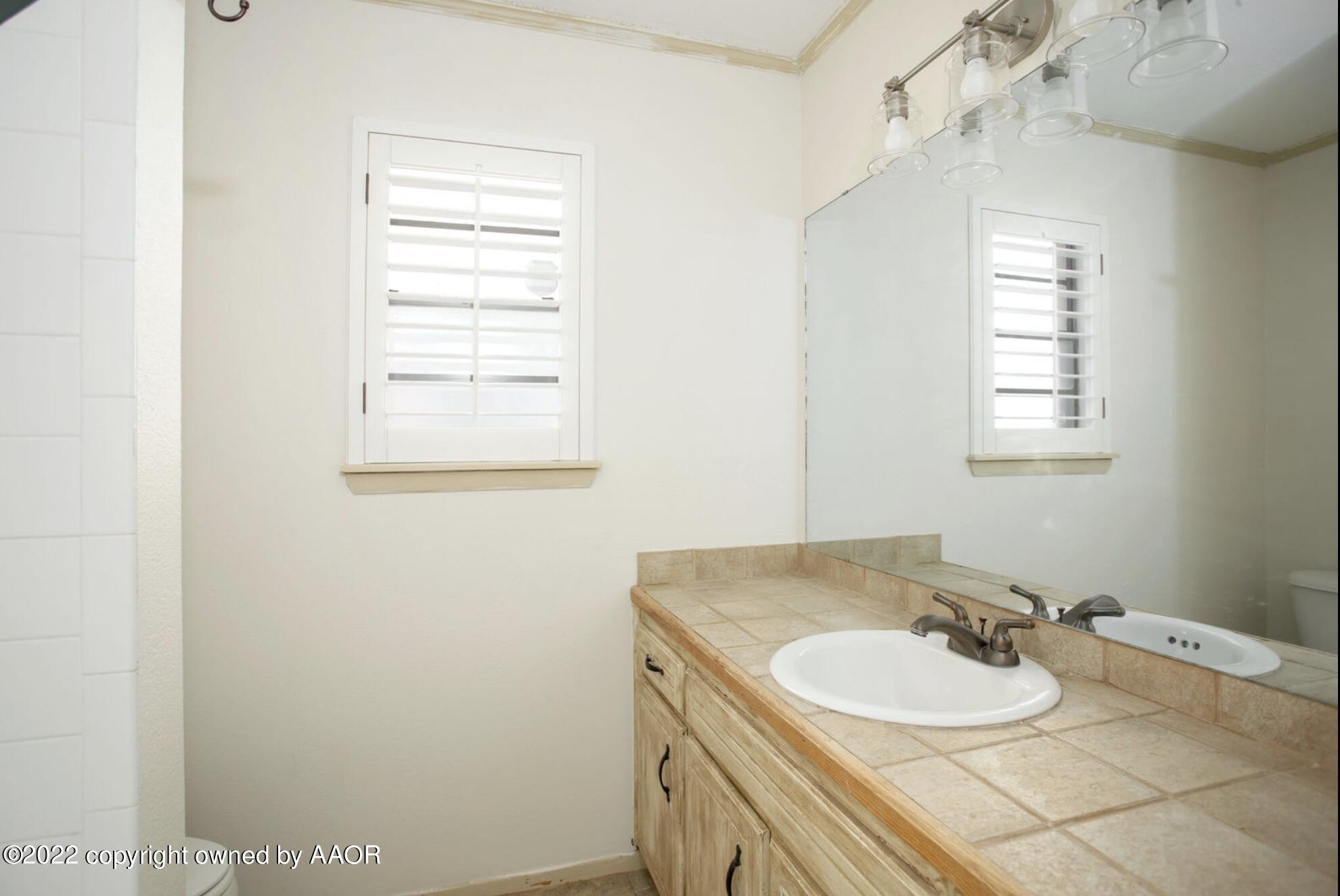 6700 Foothill Drive Amarillo, TX 79124 - Photo 4 of 17 a bathroom with a sink and a mirror