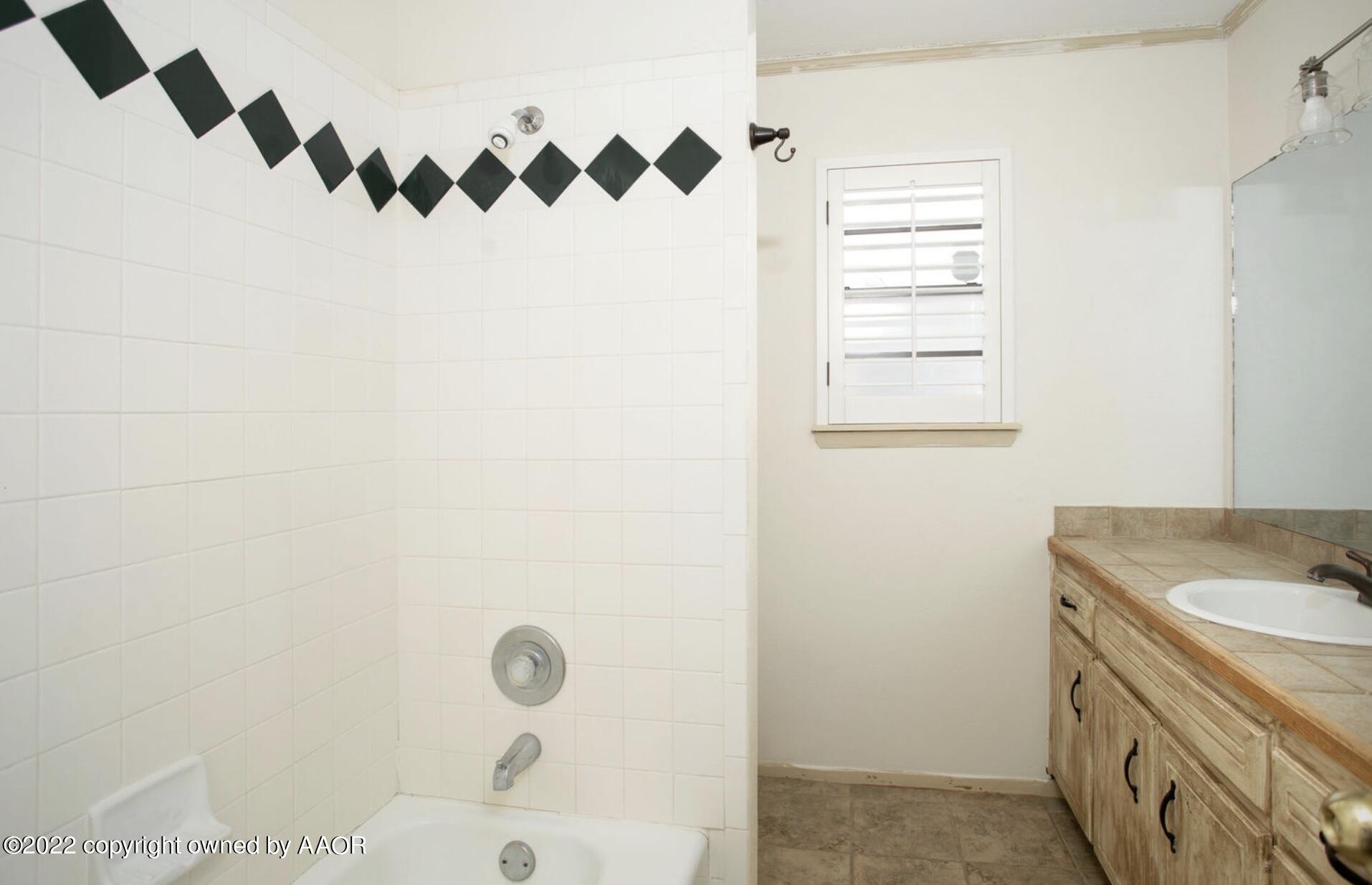 6700 Foothill Drive Amarillo, TX 79124 - Photo 5 of 17 a bathroom with a granite countertop shower a mirror and a sink