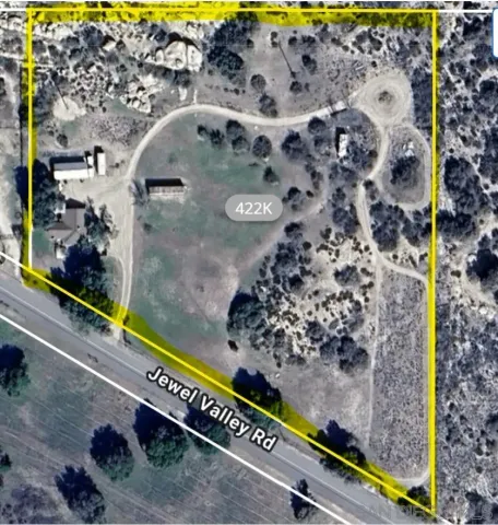 a view of house with outdoor space and trees in the background