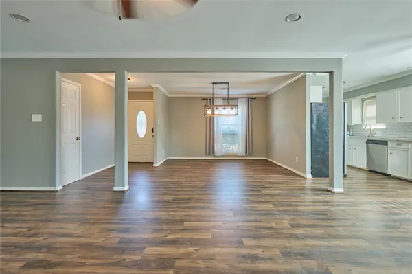 a view of a livingroom with a fireplace wooden floor and a chandelier