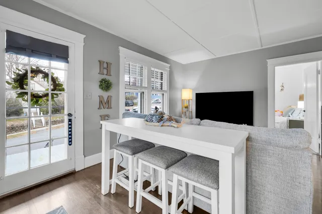 a view of a white house with a yard patio and wooden fence