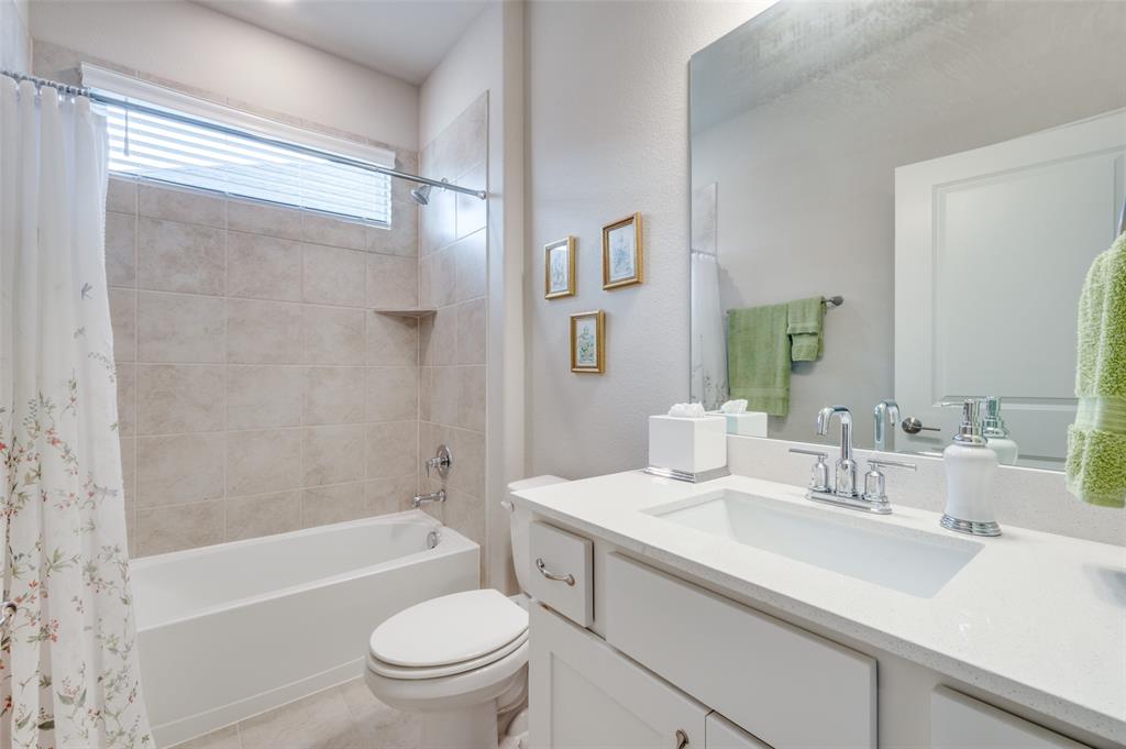 309 Savannah Lane Oak Point, TX 75068 - Photo 20 of 30 a bathroom with a granite countertop sink a toilet a mirror a bathtub and shower