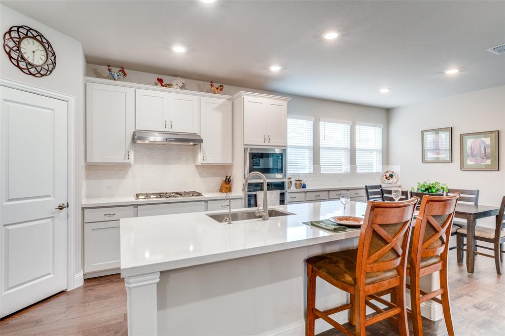 309 Savannah Lane Oak Point, TX 75068 - Photo 5 of 30 a kitchen with stainless steel appliances granite countertop a stove a sink a refrigerator with a dining table and chairs