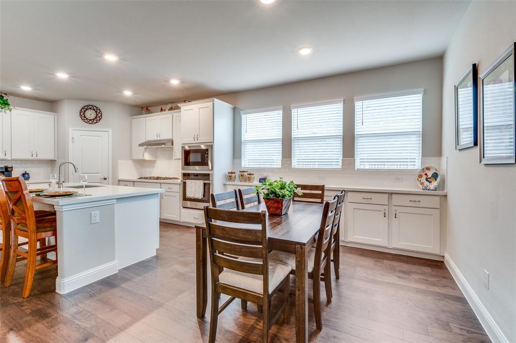 309 Savannah Lane Oak Point, TX 75068 - Photo 7 of 30 a kitchen with a table chairs sink microwave and cabinets