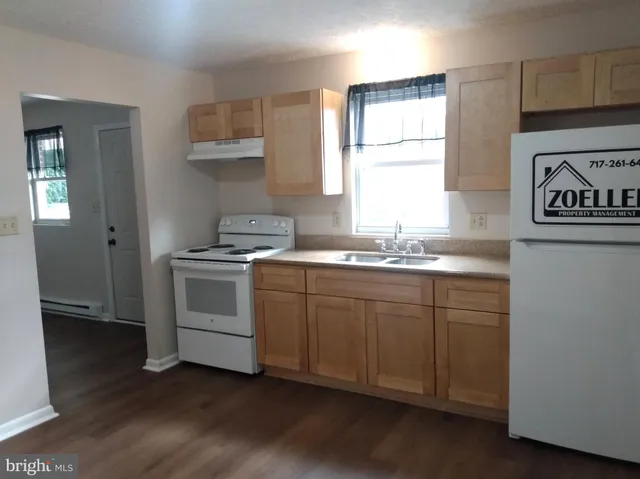 a kitchen with granite countertop white cabinets and white appliances