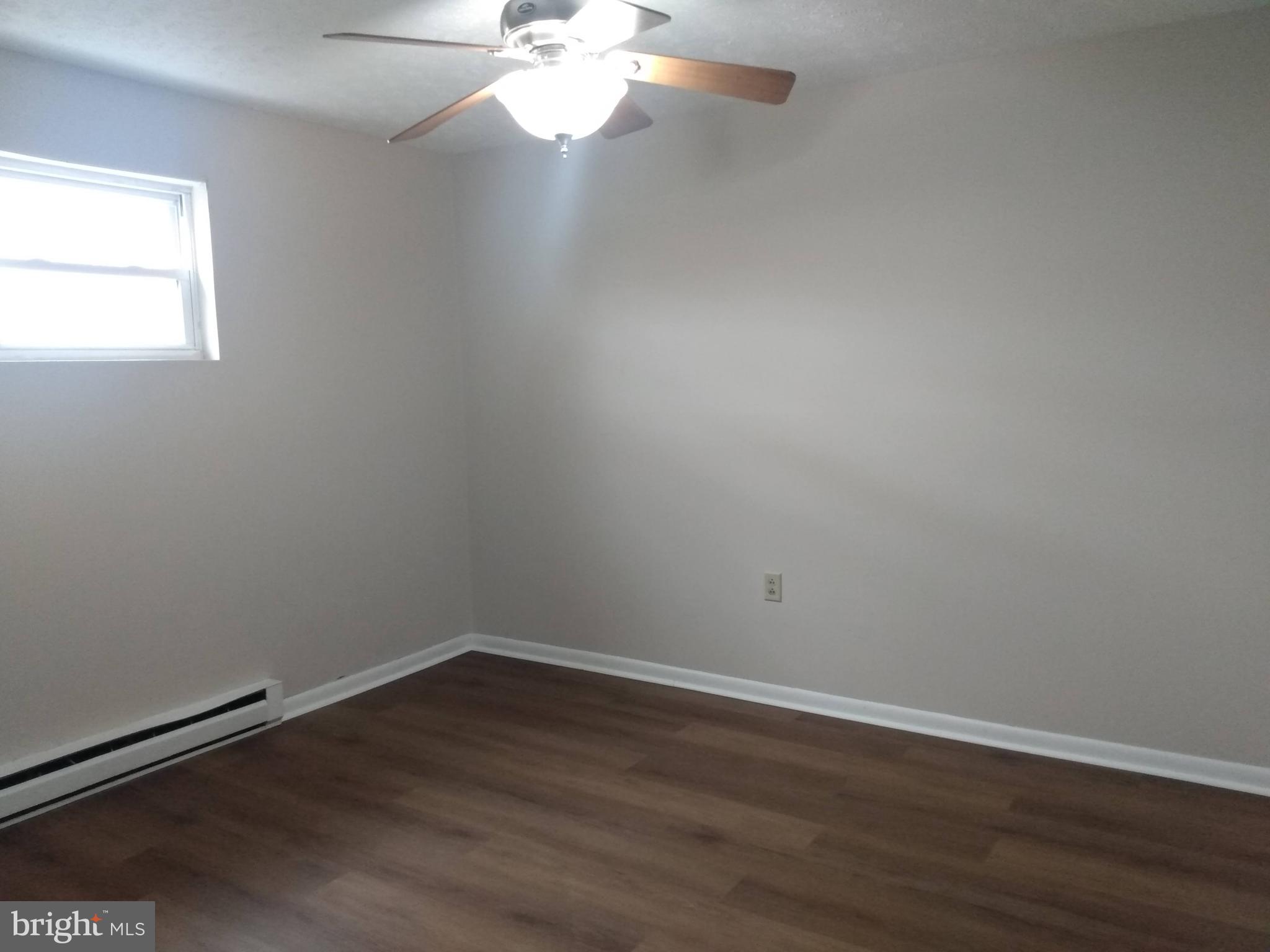 861 Buchanan Trail East, Unit 5 Greencastle, PA 17225 - Photo 8 of 14 wooden floor in an empty room with a window