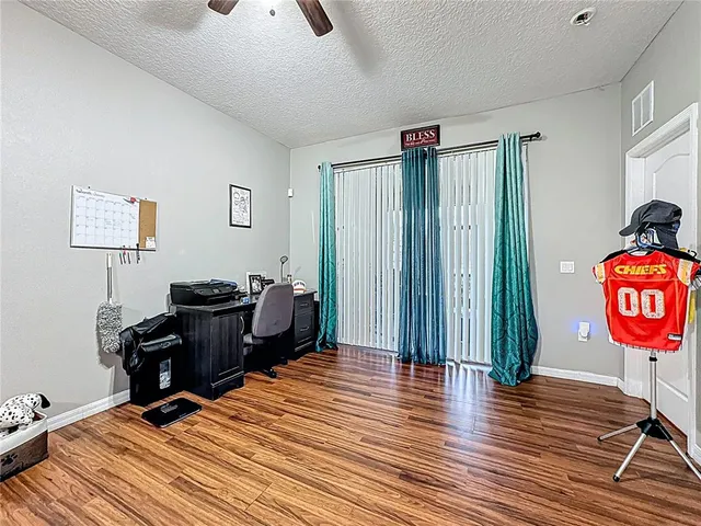 a view of a workspace with furniture and a window