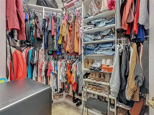 a view of walk in closet with clothes