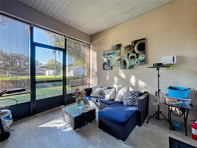 a living room with furniture and a floor to ceiling window