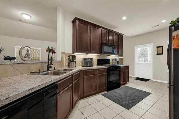 a kitchen with a sink and a stove top oven