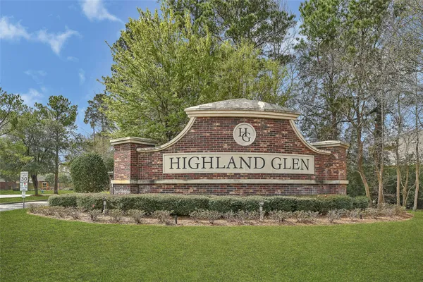 a view of sign board and large trees