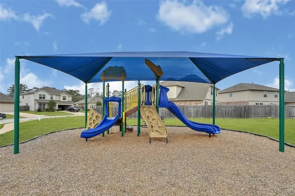 a view of sitting area with slide and wooden fence