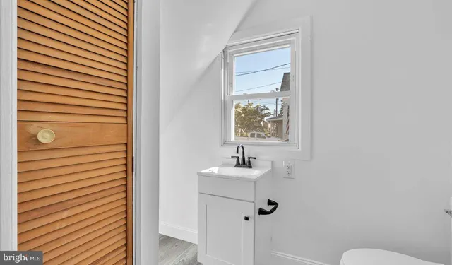 a bathroom with a sink mirror and toilet