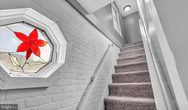 a view of staircase with rug and white walls