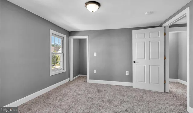 an empty room with windows and closet