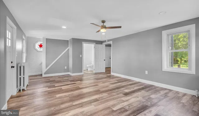a view of empty room with ceiling fan and window