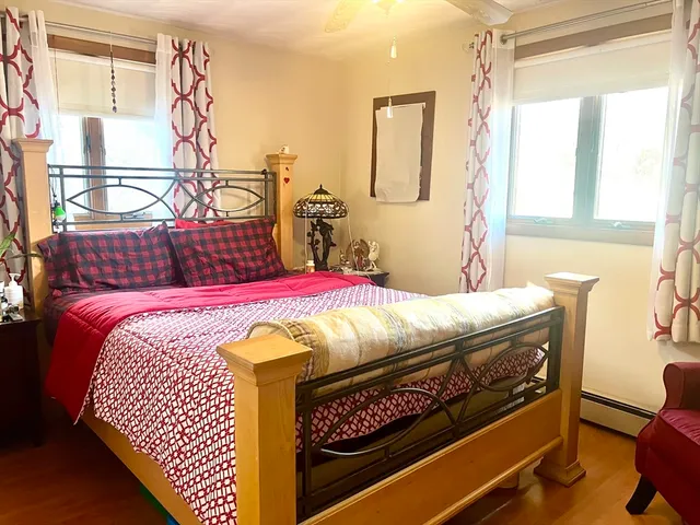 a bedroom with a bed a dresser next to a window