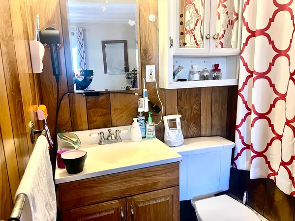 a bathroom with a sink a toilet and a mirror