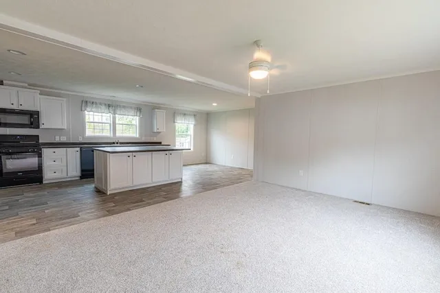 a view of a kitchen with a sink stove cabinets and a window