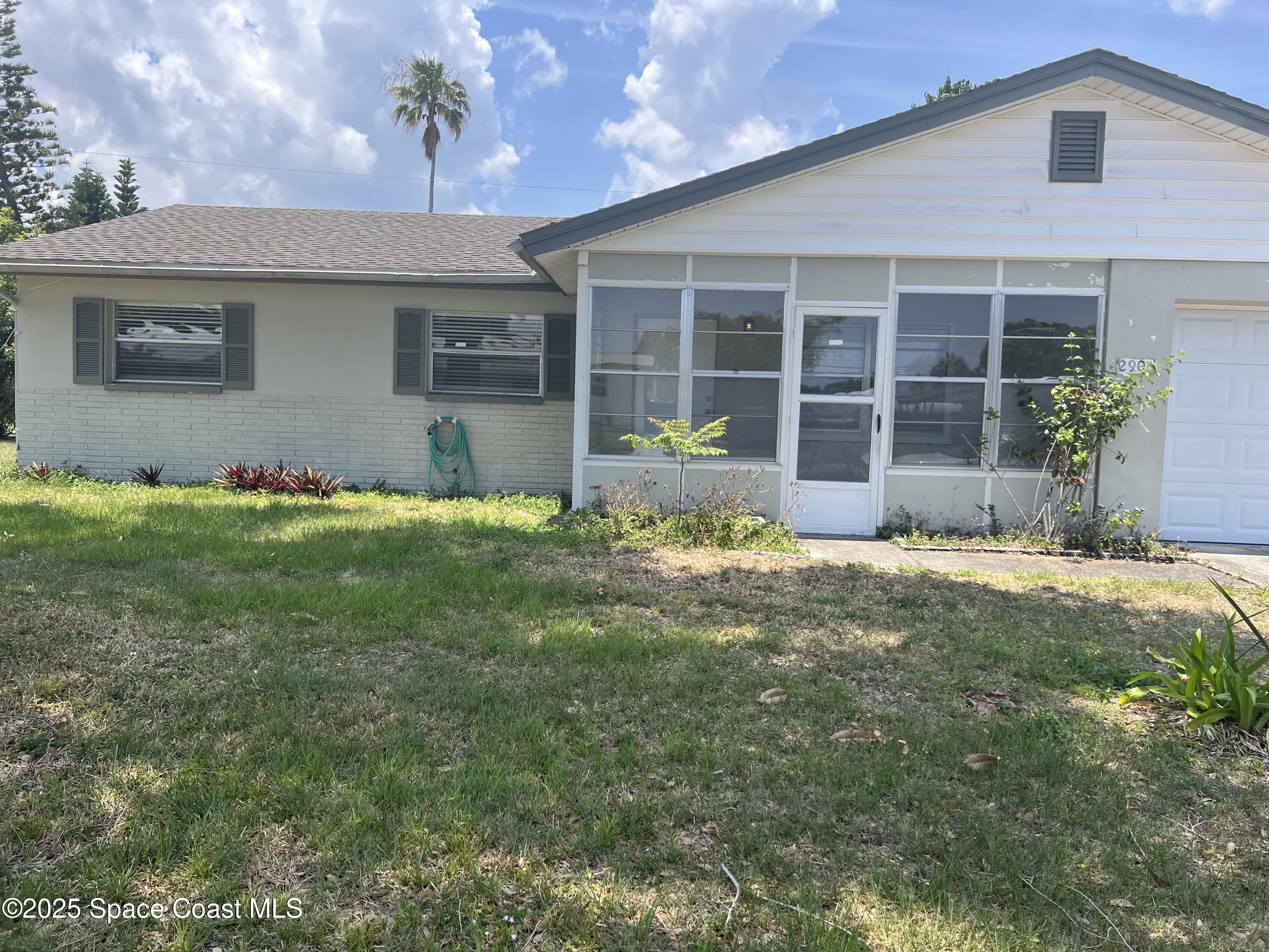 2906 Rollins Street Melbourne, FL 32901 - Photo 1 of 12 a front view of a house with a garden and yard