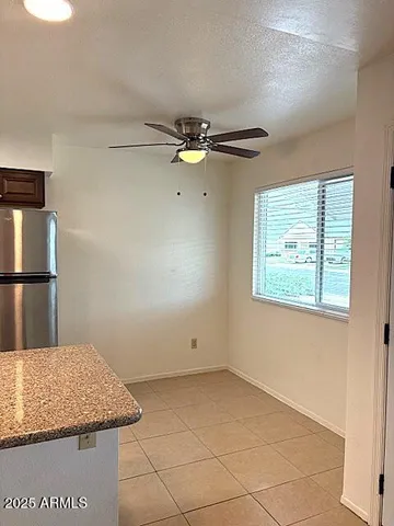 an empty room with windows and ceiling fan