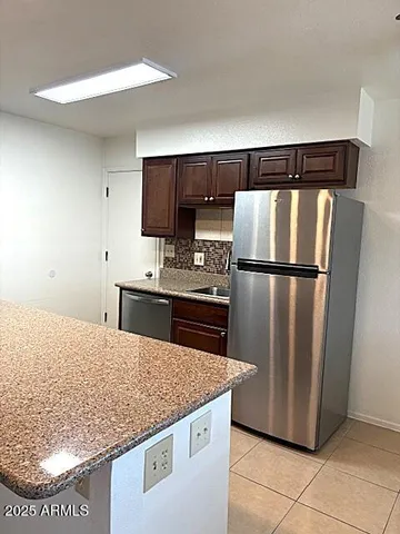 a kitchen with granite countertop a refrigerator and a sink