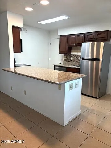 a kitchen with stainless steel appliances a refrigerator a sink a stove a microwave a counter and grass