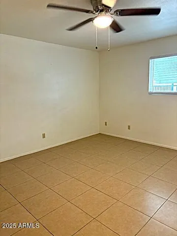 an empty room with a ceiling fan and carpet