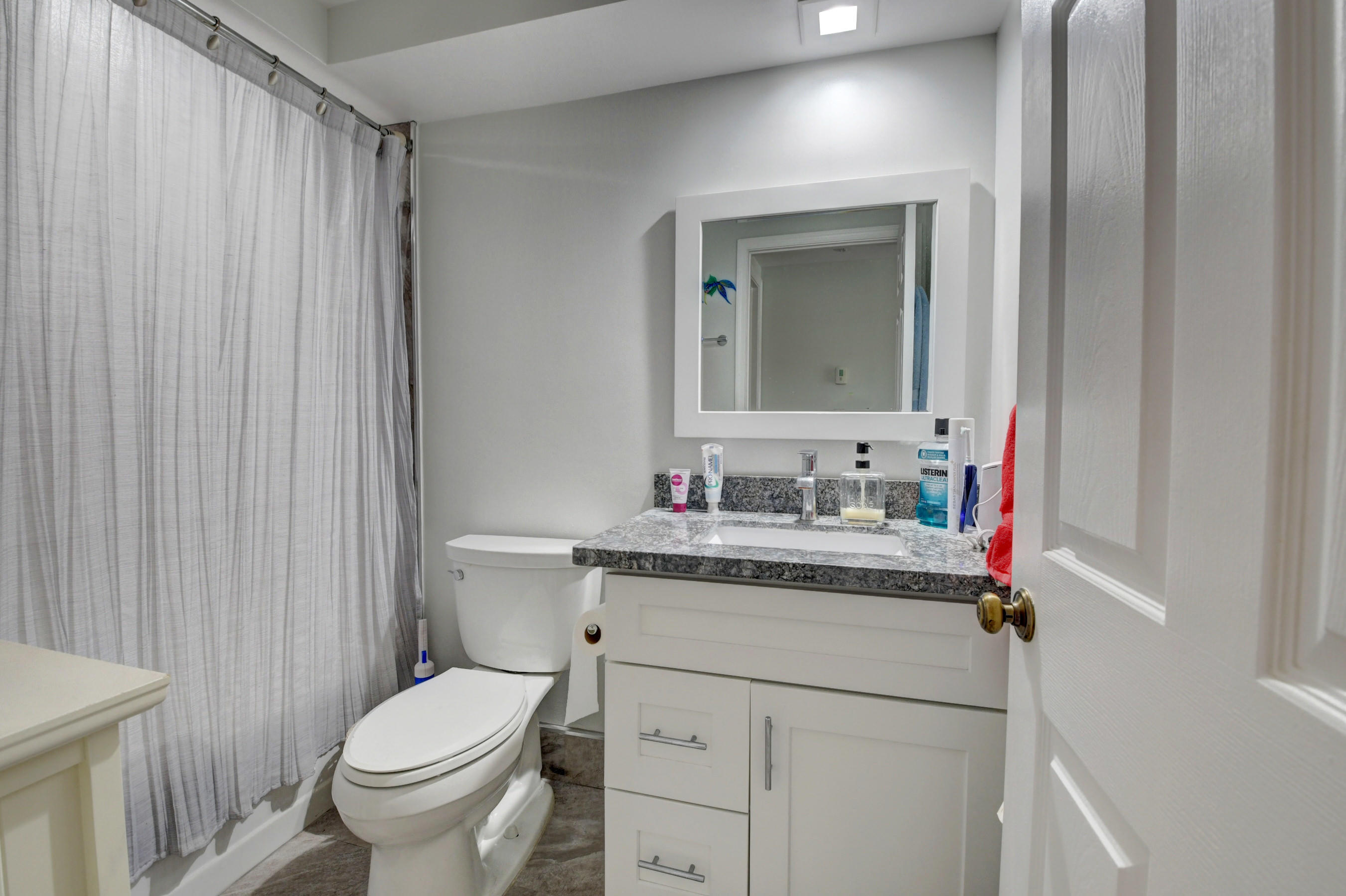 23061 Aqua View, Unit 1 Boca Raton, FL 33433 - Photo 27 of 29 a bathroom with a granite countertop sink mirror vanity and toilet