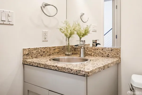 a bathroom with a granite countertop sink and a mirror