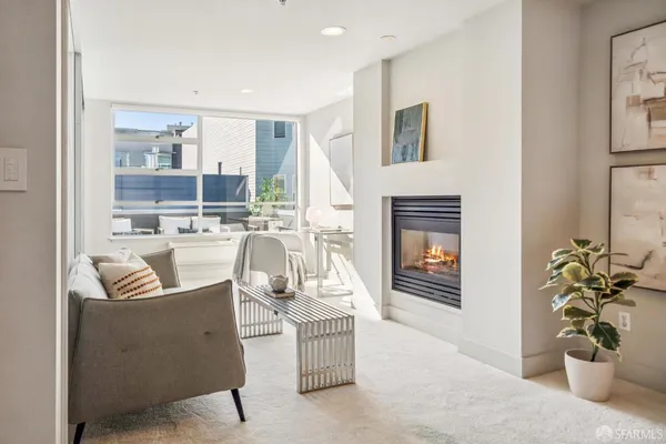 a living room with furniture a fireplace and a potted plant