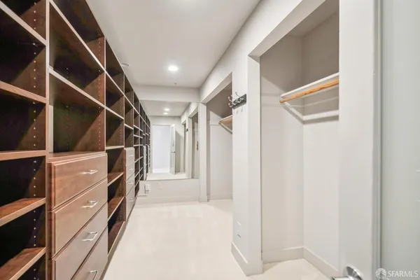 a view of walk in closet with clothes and shoes