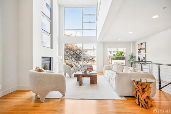 a living room with furniture wooden floor and a large window